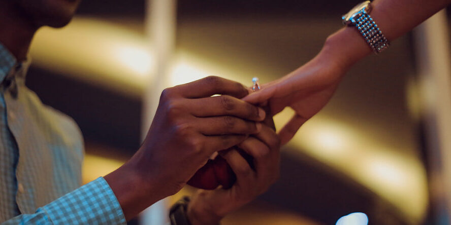 Marriage-Under-Kenya-Law-Njaga Gentleman on one knee putting a ring on his fiancée outdoors | Marriage Law in Kenya | Njaga & Co. Advocates family law firm in Kenya