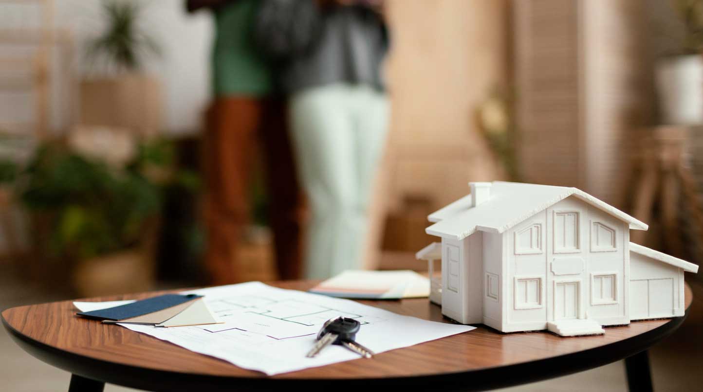 Couple standing in the sitting room with house project on the table | Njaga and Co. Advocates legal Articles | Buying Property in Kenya for Foreign Investors and Kenyans in Diaspora