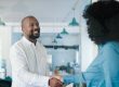 Gent all smiles shaking hands with lady in an office | Understanding Secondment in Employment under the Kenyan Legal Landscape | Employment lawyers Nairobi