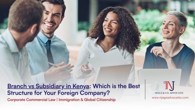 A group 4 people in official wear with laptops open while they engage all smiles | Best Foreign company structure to set up in kenya | corporate lawyers in kenya