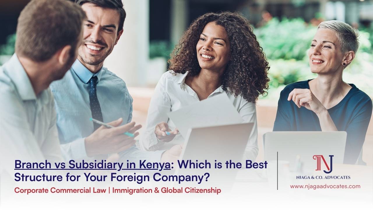 A group 4 people in official wear with laptops open while they engage all smiles | Best Foreign company structure to set up in kenya | corporate lawyers in kenya